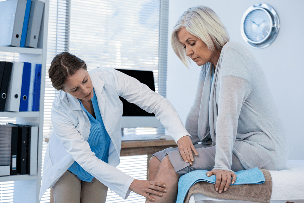 El médico examina a un paciente con osteoartritis de rodilla. 